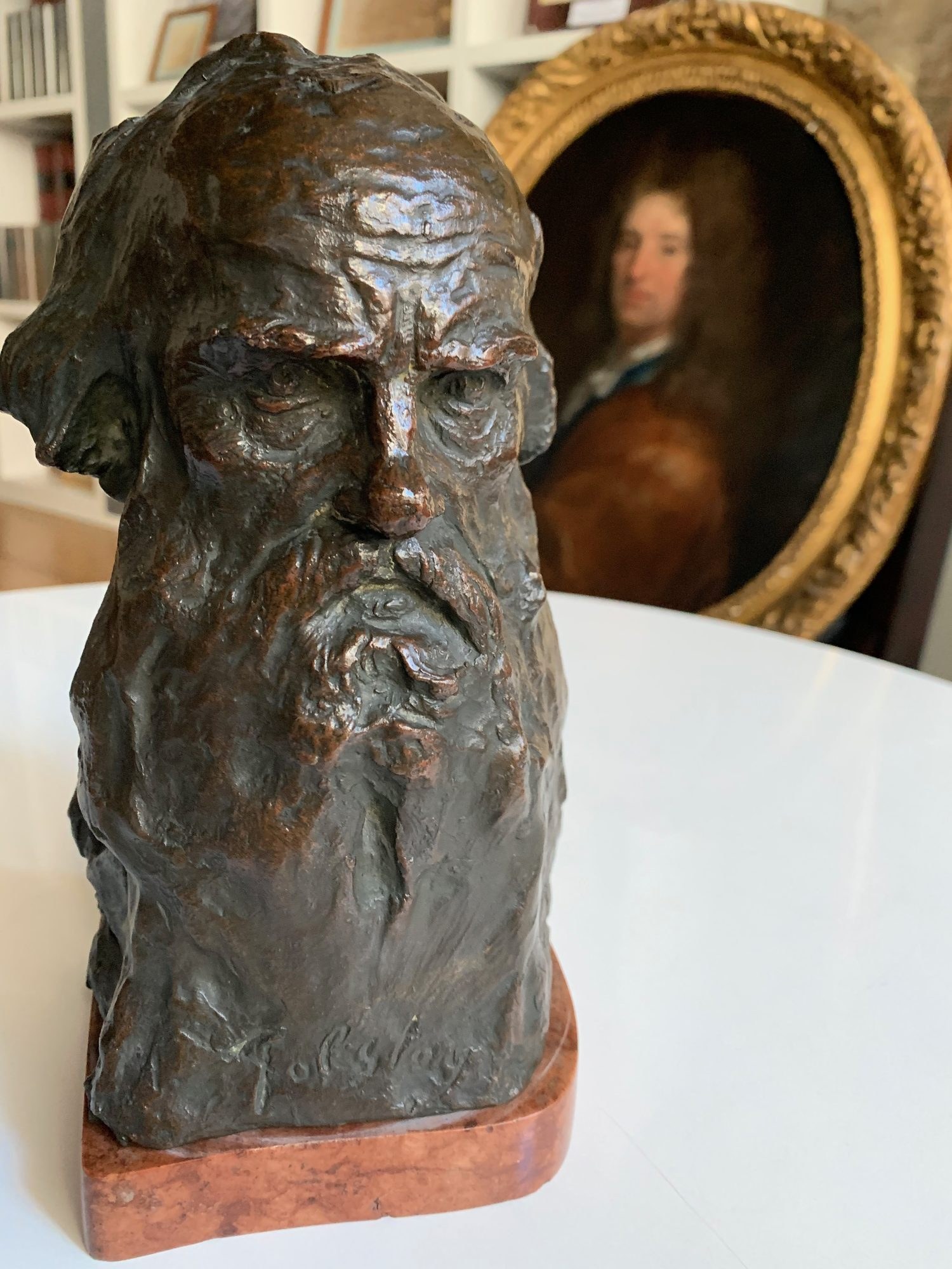 Buste en bronze d’un écrivain devant un portrait ancien encadré