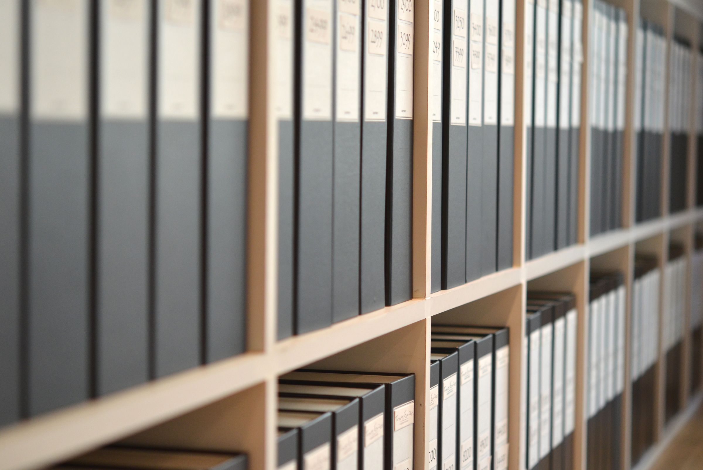 Classeurs d’archives alignés sur un rayonnage en perspective