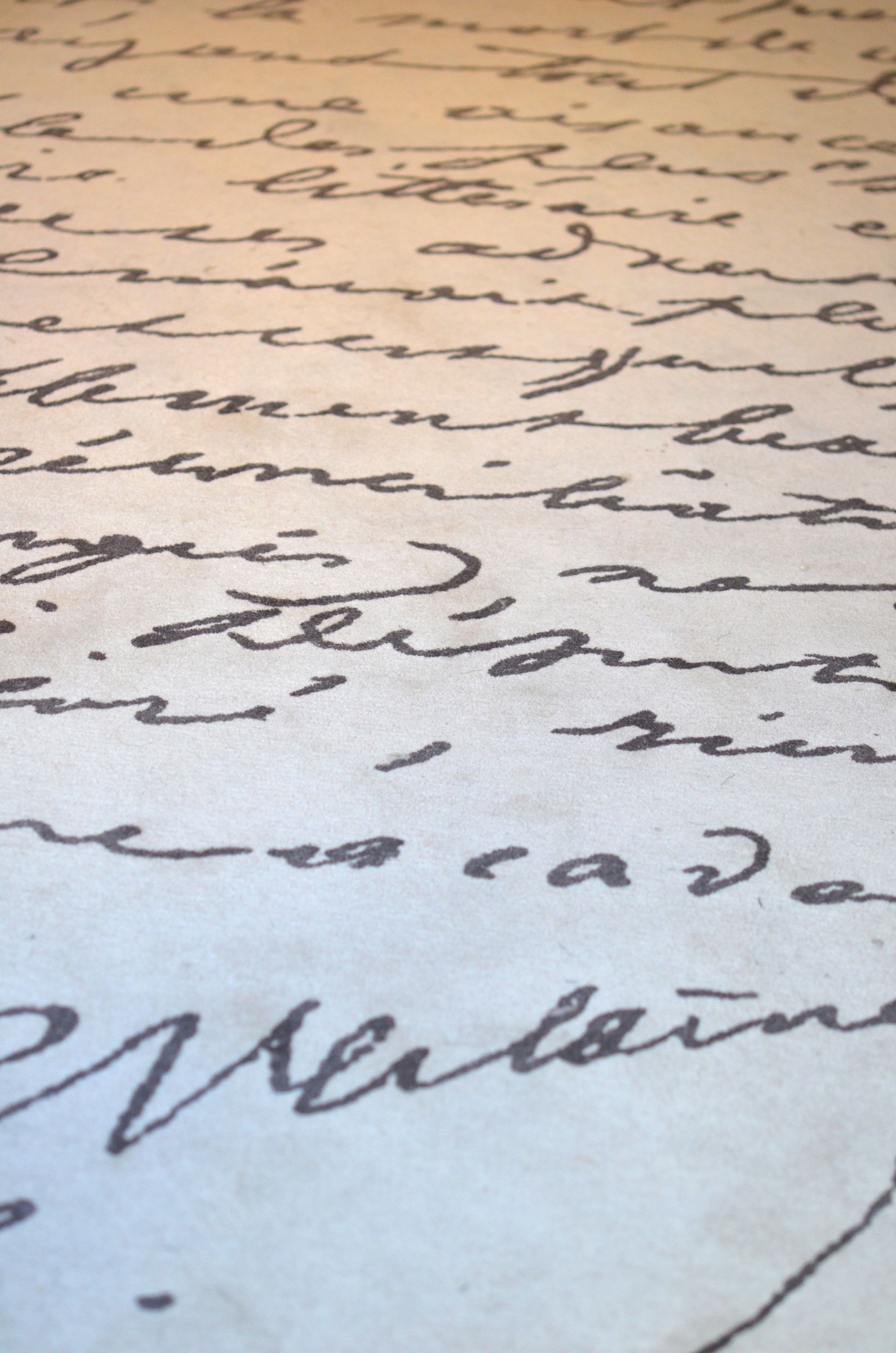 Détail du tapis de la librairie orné d’une écriture manuscrite